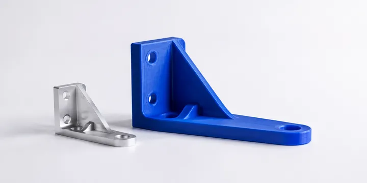 Render di due staffe funzionali: una in polimero blu con strati di stampa visibili e una in alluminio satinato